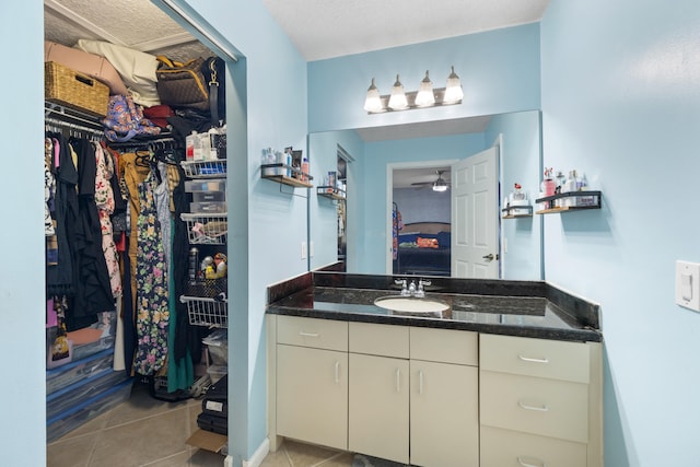 bathroom featuring vanity, ceiling fan, tile patterned flooring, and a textured ceiling