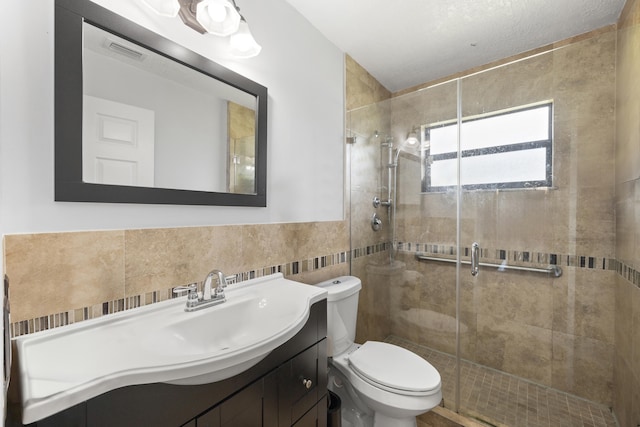 bathroom featuring tile walls, vanity, toilet, and walk in shower