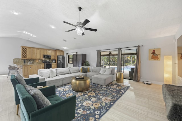 living room with light tile patterned flooring, a textured ceiling, sink, vaulted ceiling, and ceiling fan