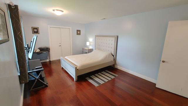 bedroom featuring dark wood-type flooring and a closet