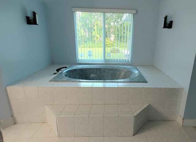 bathroom with tile patterned flooring and tiled tub