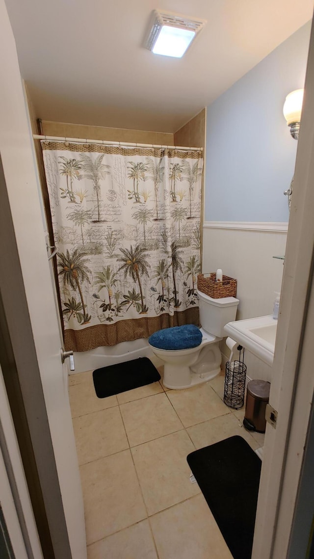 bathroom with toilet, a shower with curtain, and tile patterned flooring