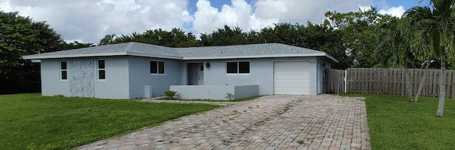 view of front of home featuring a front lawn and a garage