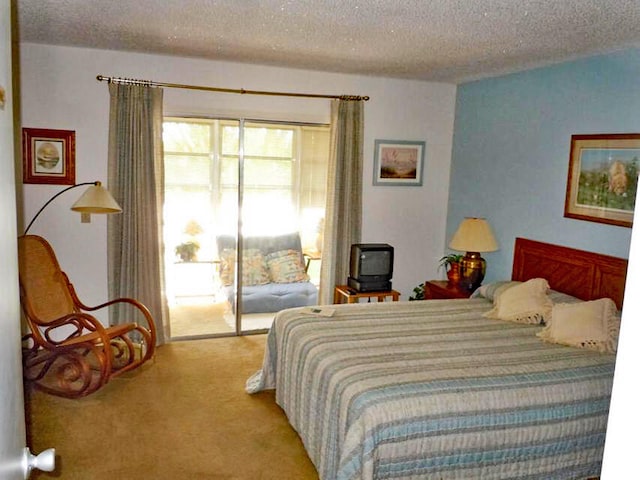 bedroom with a textured ceiling and light colored carpet