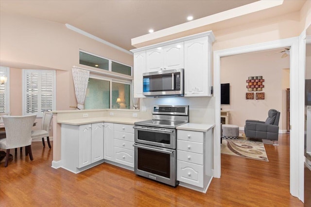 kitchen with crown molding, light hardwood / wood-style floors, stainless steel appliances, and white cabinets