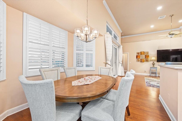 dining space with ceiling fan with notable chandelier, wood-type flooring, and crown molding