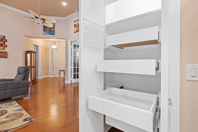 interior space with crown molding, sink, ceiling fan, and hardwood / wood-style flooring