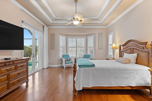 bedroom with a tray ceiling, ceiling fan, dark wood-type flooring, and access to exterior