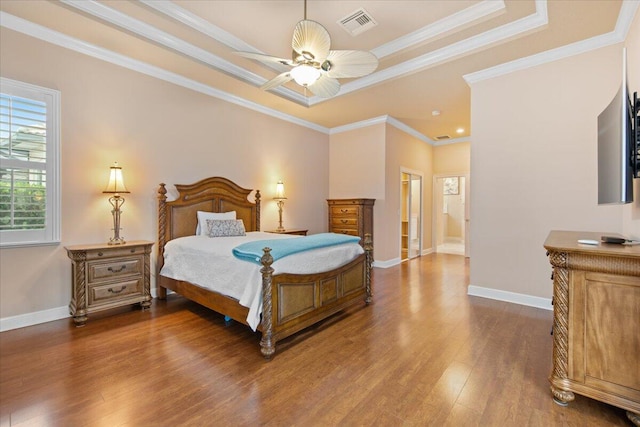 bedroom featuring crown molding, dark hardwood / wood-style floors, ceiling fan, and ensuite bath