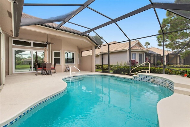 view of swimming pool featuring glass enclosure, ceiling fan, and a patio area