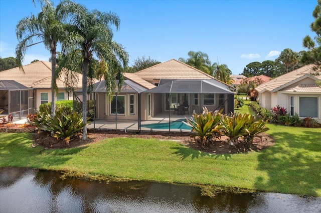 back of property with glass enclosure, a lawn, and a patio