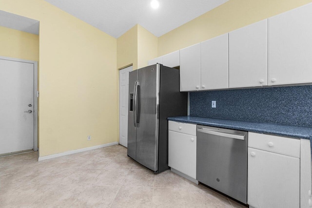 kitchen featuring white cabinets, light tile patterned floors, appliances with stainless steel finishes, and tasteful backsplash