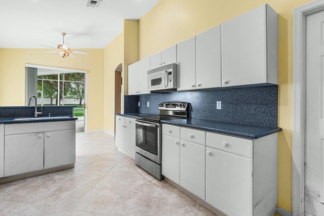 kitchen with stainless steel electric range, white cabinets, lofted ceiling, ceiling fan, and sink