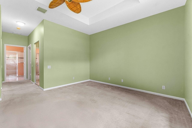 empty room featuring ceiling fan and light colored carpet