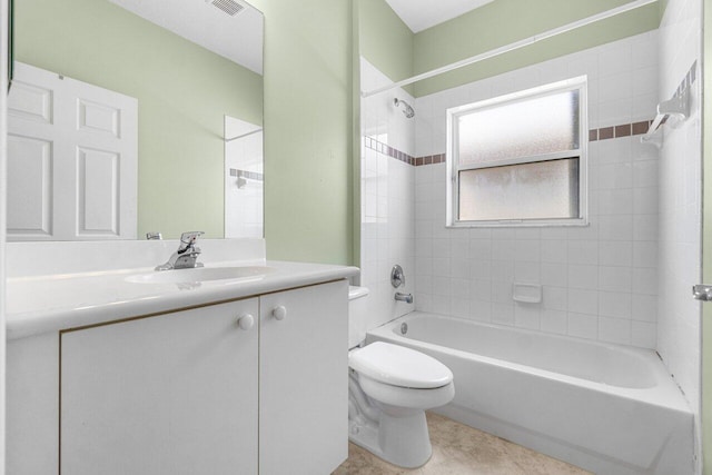 full bathroom featuring tile patterned flooring, tiled shower / bath combo, vanity, and toilet