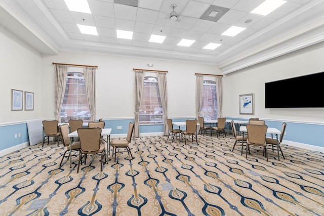 carpeted dining room featuring a paneled ceiling and ornamental molding