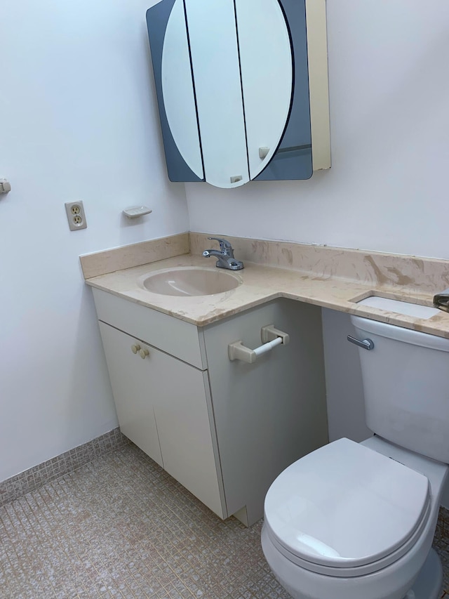 bathroom featuring vanity, tile patterned flooring, and toilet