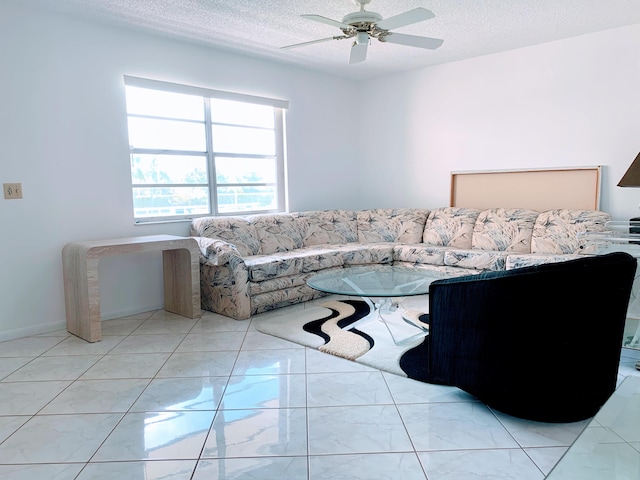 living room with ceiling fan and a textured ceiling