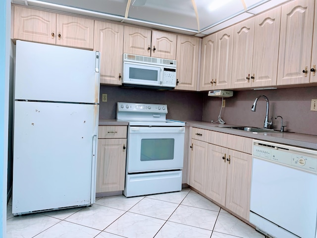 kitchen featuring white appliances, light brown cabinetry, sink, and light tile patterned floors