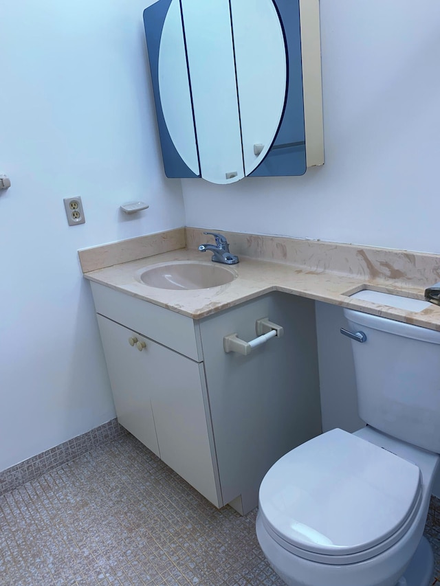 bathroom featuring tile patterned flooring, vanity, and toilet