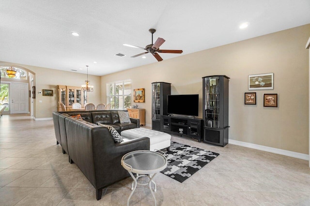 living room with ceiling fan with notable chandelier and light tile patterned floors