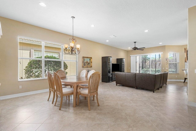 tiled dining space featuring ceiling fan with notable chandelier