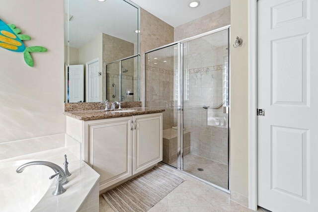 bathroom with tile patterned flooring, independent shower and bath, and vanity