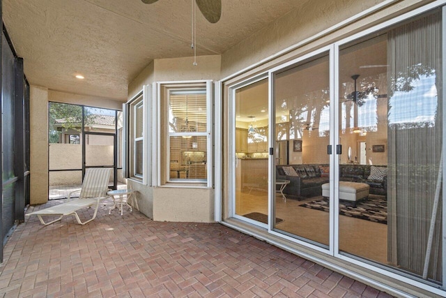 unfurnished sunroom with ceiling fan