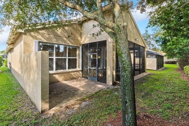 back of house with a sunroom and a patio