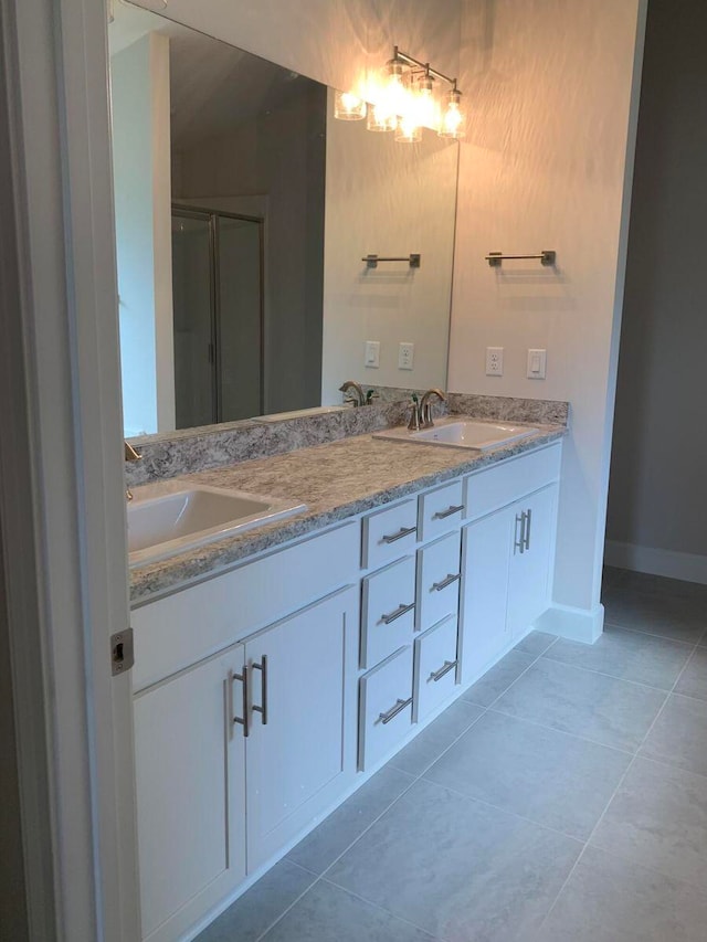 bathroom featuring tile patterned floors, a shower with door, and vanity