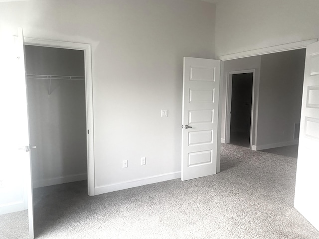 unfurnished bedroom featuring a closet and dark carpet