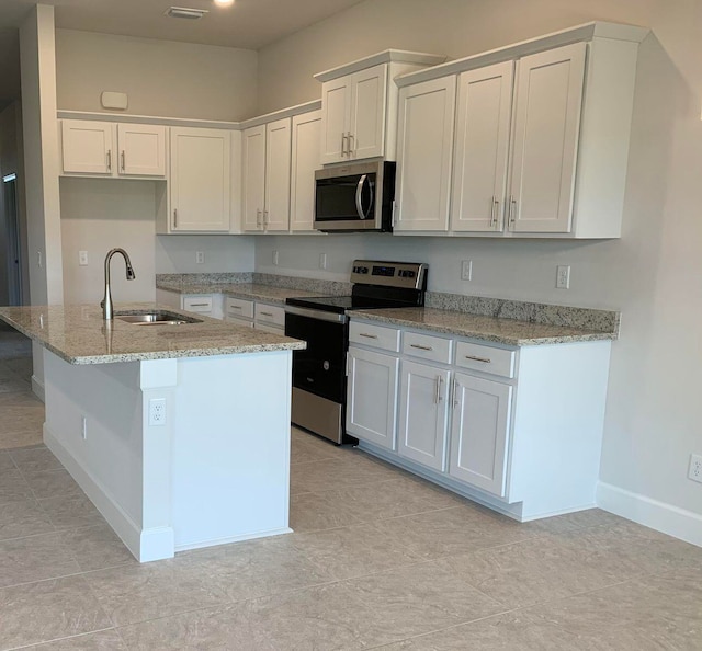 kitchen with a center island with sink, sink, stainless steel appliances, light stone countertops, and white cabinetry