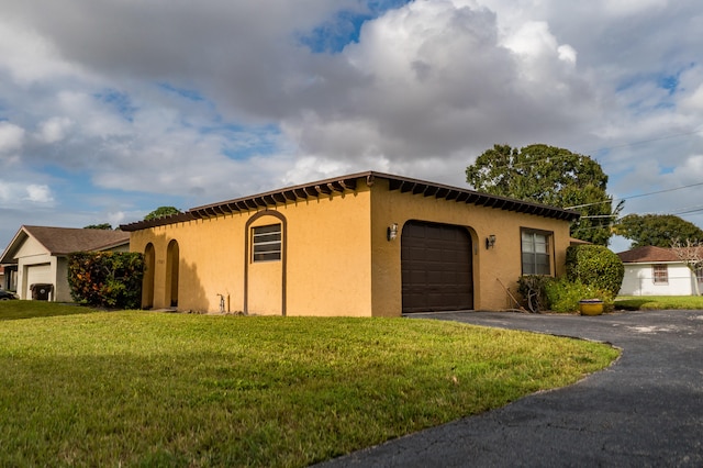 view of side of property featuring a yard and a garage