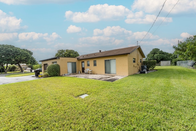 rear view of house with a yard and a patio