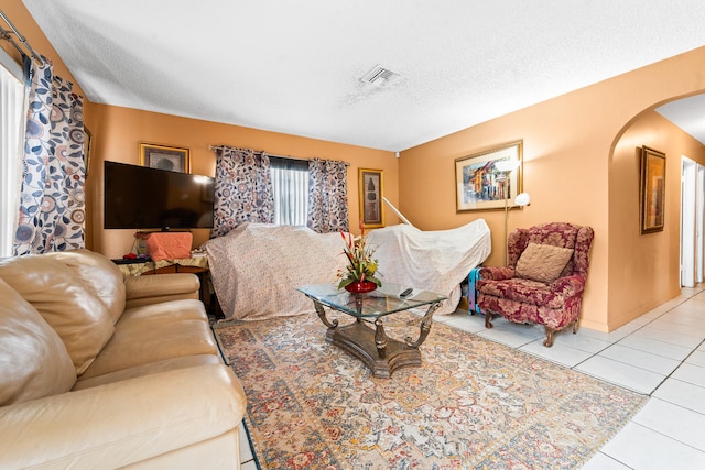 living room with light tile patterned flooring and a textured ceiling