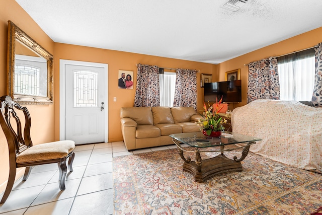 tiled living room with a textured ceiling and a healthy amount of sunlight