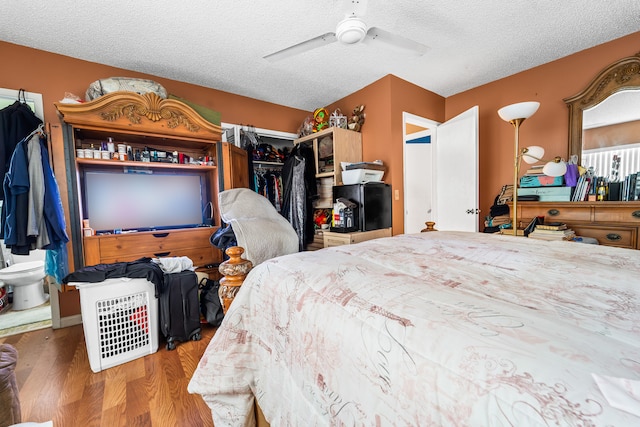 bedroom featuring hardwood / wood-style floors, a textured ceiling, and ceiling fan