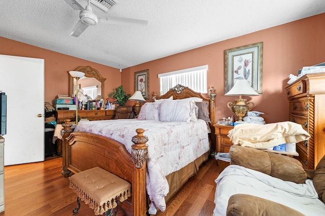 bedroom featuring a textured ceiling, hardwood / wood-style flooring, vaulted ceiling, and ceiling fan