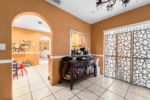 foyer featuring tile patterned floors and crown molding