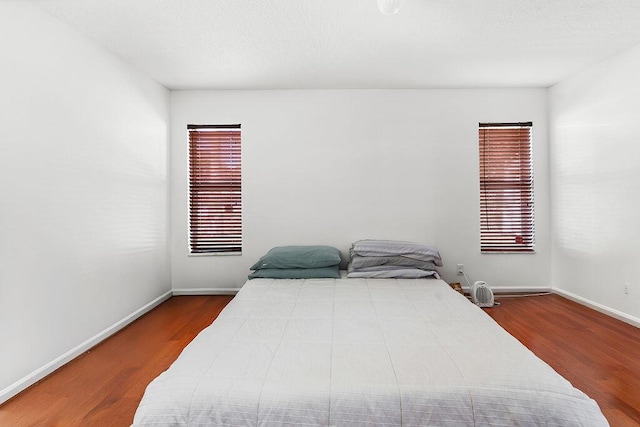 bedroom featuring multiple windows and hardwood / wood-style floors