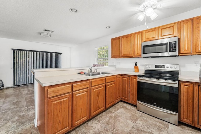 kitchen with kitchen peninsula, ceiling fan, sink, and appliances with stainless steel finishes