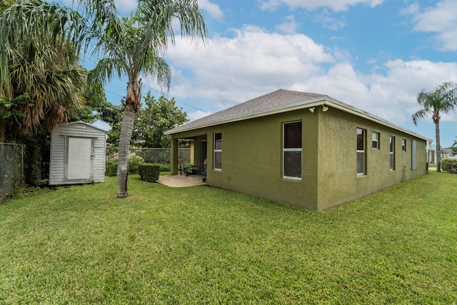 rear view of property with a yard, a patio, and a shed