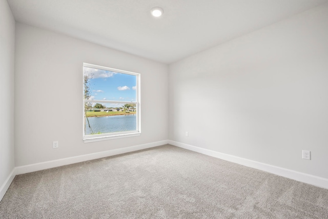 empty room with carpet flooring and a water view