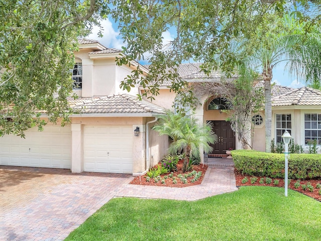 mediterranean / spanish-style home featuring a garage and a front lawn