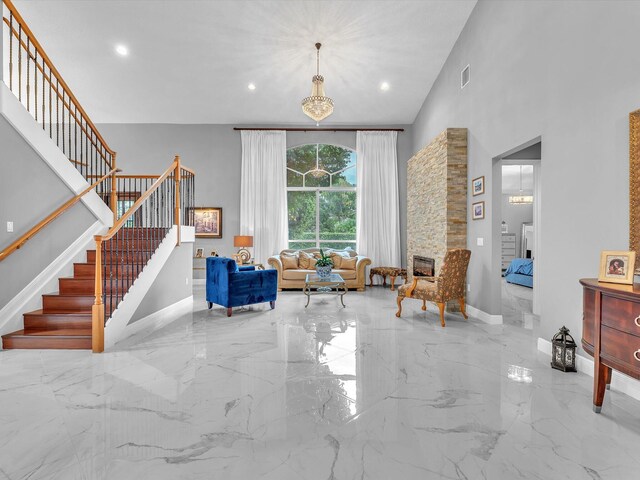 sitting room with a fireplace, a high ceiling, and a notable chandelier