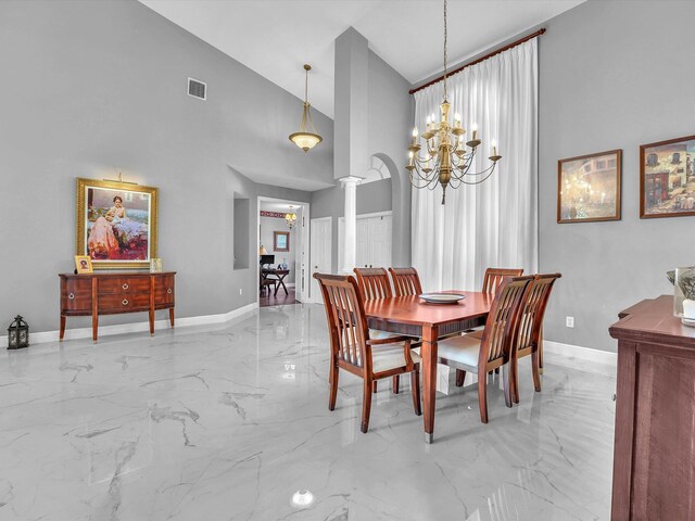 dining area with ornate columns, high vaulted ceiling, and a notable chandelier