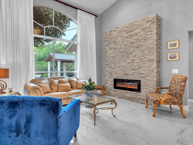 living room with a stone fireplace and plenty of natural light