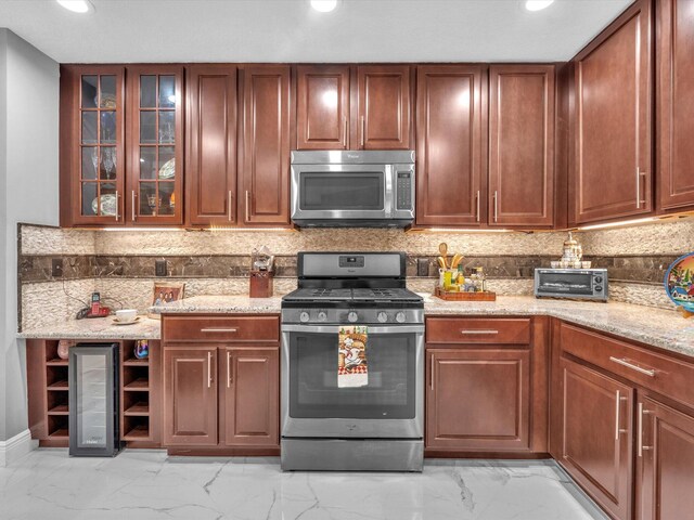 kitchen with stainless steel appliances, light stone counters, and tasteful backsplash