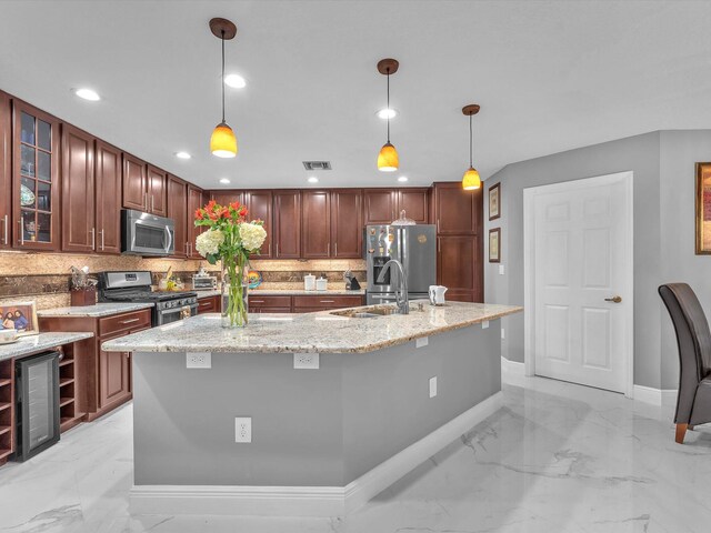 kitchen with pendant lighting, light stone counters, backsplash, and appliances with stainless steel finishes