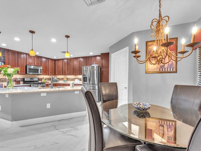 dining space with a chandelier and sink